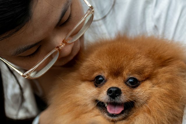 A woman carries her dog before a pet blessing ceremony on the occasion of the World Animal Day which was celebrated on October 4, at Eastwood Mall in Quezon City, Metro Manila, Philippines, on October 6, 2024. (Photo by Lisa Marie David/Reuters)