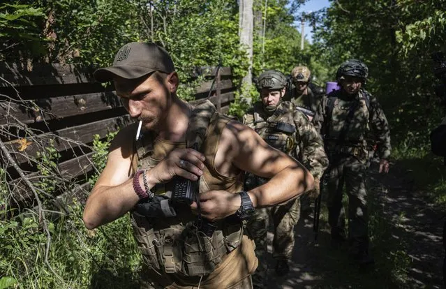 Ukrainian servicemen changing their position at the frontline near Kharkiv, Ukraine, on Saturday, July 2, 2022. (Photo by Evgeniy Maloletka/AP Photo)