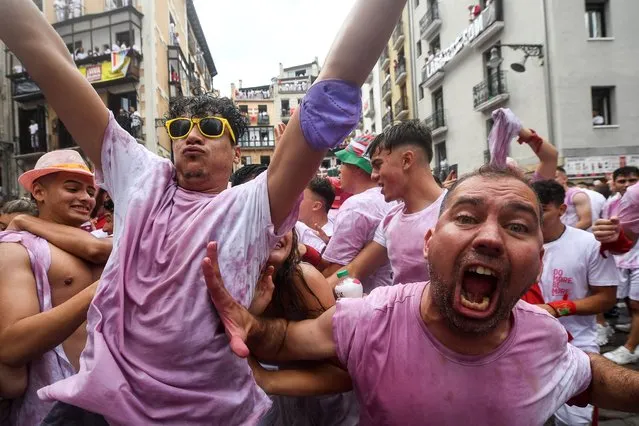 Participants celebrate before the “Chupinazo” (start rocket) opening ceremony to mark the kick-off of the San Fermin Festival outside the Town Hall of Pamplona in northern Spain on July 6, 2022. (Photo by Miguel Riopa/AFP Photo)