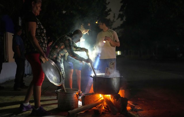 Residents prepare a soup over an open fire during a blackout following the failure of a major power plant, in Havana, Cuba, Saturday, October 19, 2024. (Photo by Ramon Espinosa/AP Photo)