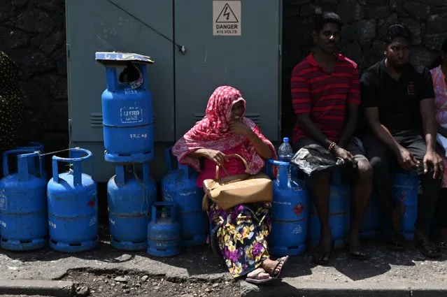 People wait in a queue to collect Liquefied Petroleum Gas (LPG) cylinders at a distribution point in Colombo on July 12, 2022. (Photo by Arun Sankar/AFP Photo)