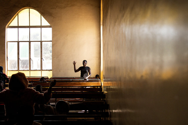 A follower of the Apostolic Faith Mission raises her hand as she prays for a peaceful election, during a mass at the Gospel Fire Cathedral in the historic township of Mbare in Harare on August 20, 2023. Zimbabweans will head to the polls on August 23, 2023 to vote in general and presidential elections. (Photo by John Wessels/AFP Photo)