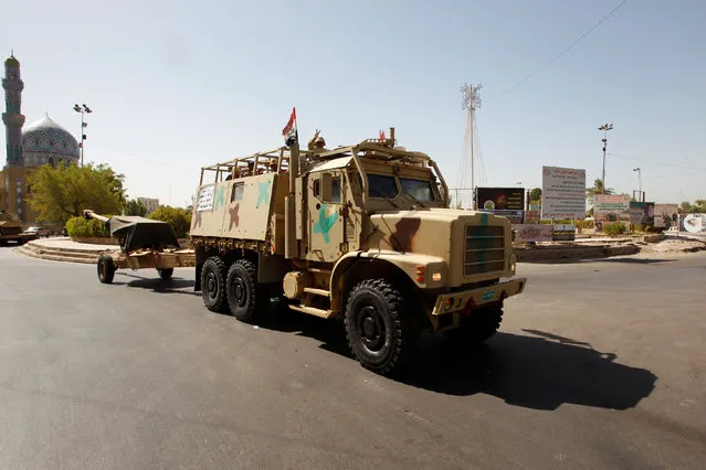 Iraqi security forces vehicles take part in a military parade in the streets of Baghdad, Iraq July 12, 2016. Social media activists posted images of tanks, armored vehicles, cannons, soldiers, police officers, and PMF members in Saadoun Street. The photos spiked a rumor of military coup. (Photo by Khalid al Mousily/Reuters)