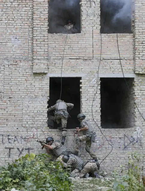 Members of the Ukrainian Interior Ministry's special battalion Kiev-1 storm a building during an anti-terror drill in Kiev, Ukraine, August 28, 2015. (Photo by Valentyn Ogirenko/Reuters)