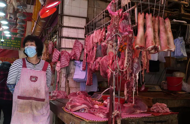 A vendor wears a face mask selling meat at a market in Hong Kong, Friday, January 31, 2020. The World Health Organization declared the outbreak sparked by a new virus in China that has spread to more than a dozen countries a global emergency after the number of cases spiked more than tenfold in a week, including the highest death toll in a 24-hour period reported Friday. (Photo by Vincent Yu/AP Photo)