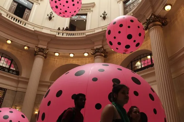 Visitors walk next to inflatable plastic balloons, part of the “Dots Obsession” exhibition created by Japanese pop artist Yayoi Kusama in Rio de Janeiro October 17, 2013.. (Photo by Pilar Olivares/Reuters)