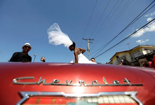 Bride Dayami Tellez of Havana, Cuba, boards a 1958 Chevrolet Impala convertible car after her wedding with groom Joaquin Camacho of Spain in Havana March 21, 2012. (Photo by Desmond Boylan/Reuters)