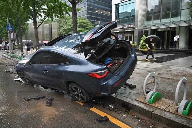 A car damaged by flood water is seen on the street after heavy rainfall at Gangnam district in Seoul on August 9, 2022. (Photo by Jung Yeon-je/AFP Photo)