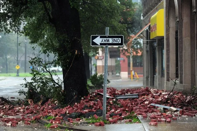 A street sign is turned upside down likely resulting from bricks falling overnight from a building along the deserted streets of New Orleans on Aug. 29, as Hurricane Isaac battered the city and surrounding region. (Photo by Frederic J. Brown/AFP)