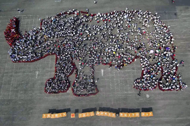 In this photo released by Leofoo Tourism Group, people gathered to form a shape of rhino to mark the 8th anniversary of World Rhino Day outside an animal-themed park in Hsinchu County, Taiwan, Friday, September 22, 2017. Hundreds of people took part in the rally organized for the first time in Taiwan to raise awareness to worldwide effort to save rhinos from extinction. Participants gathered put red stickers on their noses, a symbol of rhinos bleeding from their nose who have lost their horn. (Photo by Leofoo Tourism Group via AP Photo)