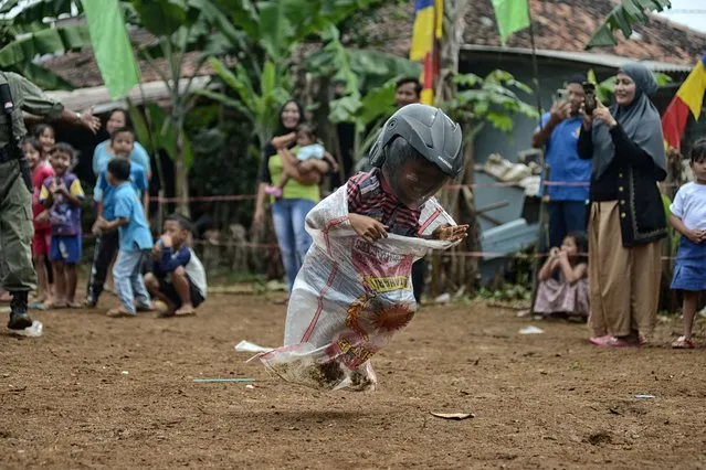 A child participated sack race game wearing helmet competition to commemorate Indonesia's 77th Independence Day in Bogor, West Java, Indonesia, on August 17, 2022. (Photo by Adriana Adie/NurPhoto via Getty Images)