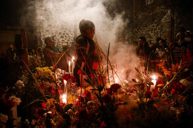 A woman takes part of Day of the Dead celebrations at San Andres Mixquic pantheon in Mexico City, on November 2, 2023. (Photo by Rodrigo Oropeza AFP Photo)