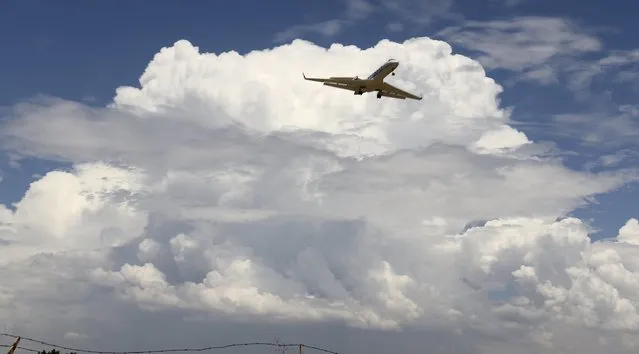 A privet jet comes in for a landing at the Van Nuys airport with huge monsoon storm cells clouds in the skies during monsoon rains in the high desert area of Los Angeles County, California July 30, 2015. (Photo by Gene Blevins/Reuters)
