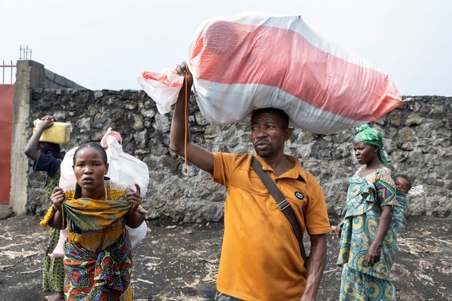 Civilians carry their belongings as they flee from the Nzulo camp for the internally displaced to Goma, as fighting intensifies between the M23 rebels and the Armed Forces of the Democratic Republic of the Congo (FARDC), near Goma, Democratic Republic of Congo on January 22, 2025. (Photo by Arlette Bashizi/Reuters)