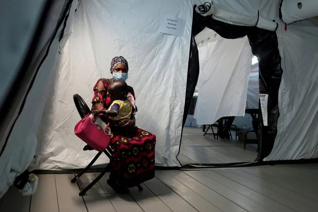 A woman holds her child as she waits for examination at the army field hospital, amid the outbreak of the coronavirus disease (COVID-19) in Touba, Senegal on May 1, 2020. (Photo by Zohra Bensemra/Reuters)
