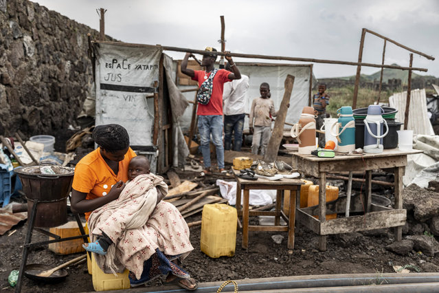 A woman holds a child as people dismantle tents to salvage materials in a refugee camp in Bulengo, Democratic Republic of Congo, 11 February 2025. Displaced persons living in the Bulengo refugee camps were given until 11 February by the M23 armed group to vacate the camp and go back to their villages and towns. The United Nations Office for the Coordination of Humanitarian Affairs, OCHA, announced that more than 110,000 displaced people in Goma, the capital of North Kivu which has fallen under the M23 armed group control, had taken to the road again to try to find refuge elsewhere in the region. (Photo by Nadaa Kahashy/EPA/EFE)