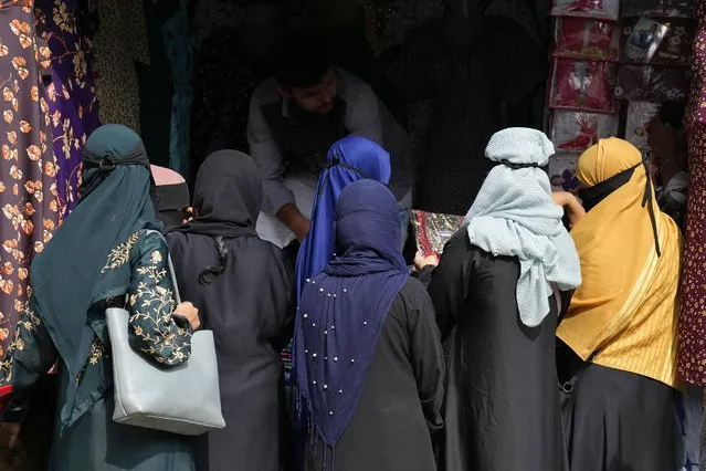 A group of veiled Muslim women shop for clothes in Bengaluru, India, Thursday, October 13, 2022. Two judges on India's top court on Thursday differed over a ban on the wearing of the hijab, a headscarf used by Muslim women, in educational institutions and referred the sensitive issue to a larger bench of three or more judges to settle. (Photo by Aijaz Rahi/AP Photo)