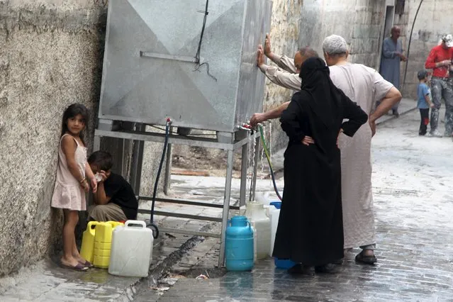 Residents fill water containers in Aleppo, Syria September 15, 2015. (Photo by Abdalrhman Ismail/Reuters)