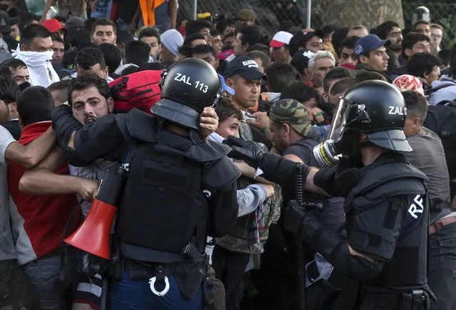 Hungarian riot police fight migrants at the border crossing with Serbia in Roszke, Hungary September 16, 2015. (Photo by Marko Djurica/Reuters)