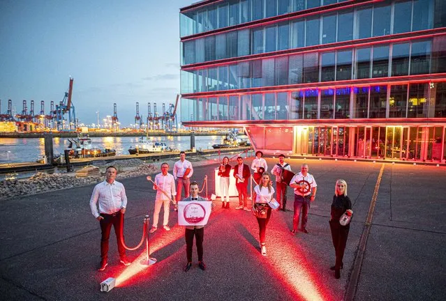 Representatives from various trades of the event industry stand together for a group photo to promote the “Night of Light” campaign in Hamburg, Germany on June 21, 2020. In the night from 22.06. to 23.06.2020, numerous companies from the event industry will be illuminating their buildings with red lighting to draw attention to the dramatic situation in the event industry. (Photo by Daniel Reinhardt/picture alliance via Getty Images)