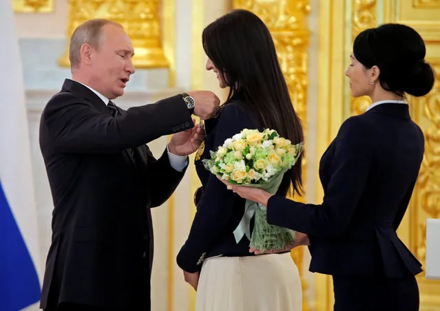 Russian President Vladimir Putin awards fencer Yana Egorian during a ceremony for Russian Olympic medallists returning home from the 2016 Rio Olympics, at the Kremlin in Moscow, Russia August 25, 2016. (Photo by Maxim Shemetov/Reuters)