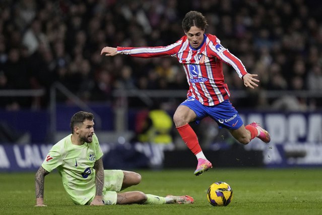 Atletico Madrid's Rodrigo Riquelme, right, goes for the ball past Barcelona's Inigo Martinez during a La Liga soccer match between Atletico Madrid and FC Barcelona at the Metropolitano stadium in Madrid, Sunday, March 16, 2025. (Photo by Bernat Armangue/AP Photo)