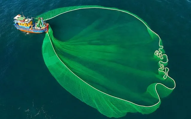 Vietnamese fishermen cast their giant nets to catch anchovy fish off the coast of Phu Yen province on May 13, 2020. Anchovy is one of the main ingredients in fish sauce and these catches are exported around Asia. (Photo by Nguyen Sanh Quoc Huy/Triangle News)