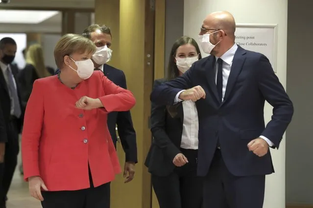European Council President Charles Michel, right, greets German Chancellor Angela Merkel, left, with an elbow bump during a round table meeting at an EU summit in Brussels, Friday, July 17, 2020. Leaders from 27 European Union nations meet face-to-face on Friday for the first time since February, despite the dangers of the coronavirus pandemic, to assess an overall budget and recovery package spread over seven years estimated at some 1.75 trillion to 1.85 trillion euros. (Photo by Stephanie Lecocq/Pool Photo via AP Photo)