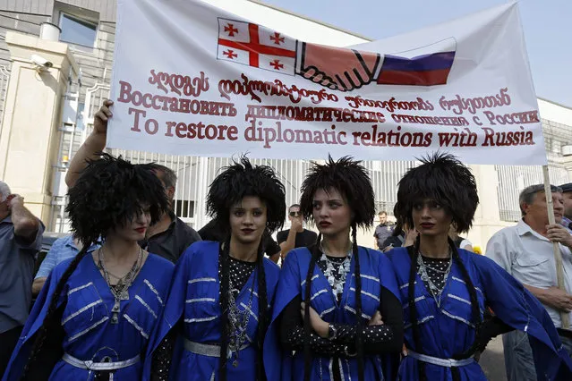 Georgian girls dressed in national costumes attend a pro-Russian protest rally in front of President's residence in Tbilisi, Georgia, 24 September 2015. Pro-Russian activists in Georgia demand to restore diplomatic relations with Russia which were severed after Georgia-Russia conflict in 2008. (Photo by Zurab Kurtsikidze/EPA)