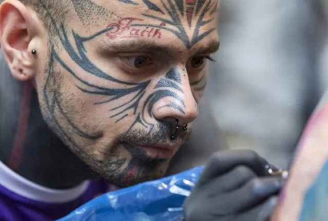 A tattoo artist concentrates on his work during the International London Tattoo Convention in east London, Britain September 26, 2015. (Photo by Neil Hall/Reuters)