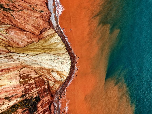 The clear blue water off Sidmouth in Devon, UK in March 2025 turned an orangey-red hue as tonnes of 200 million-year-old sandstone was mixed in by the tide. The 500ft cliff suffered a massive fall in October last year, and took a large section of Otter sandstone and Mercia mudstone with it. (Phoot by Dean Penn/RedZepplin/Bournemouth News)