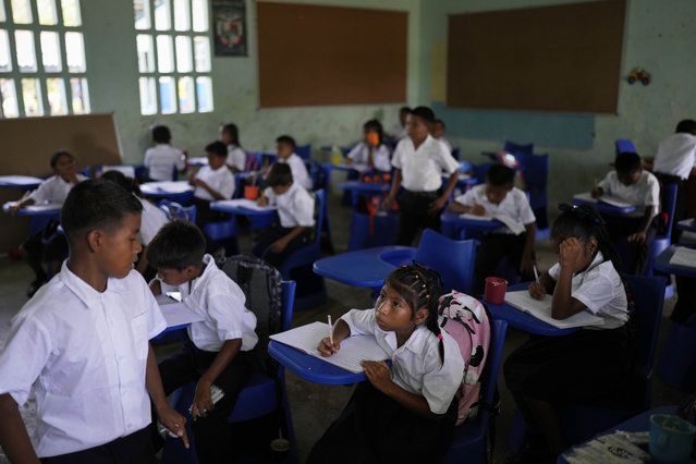 Students attend class in Villa Caleta, a community in Panama that used to benefit economically by being on the route migrants took after crossing the Darien Gap on their way north to the U.S., Monday, April 7, 2025. (Photo by Matias Delacroix/AP Photo)