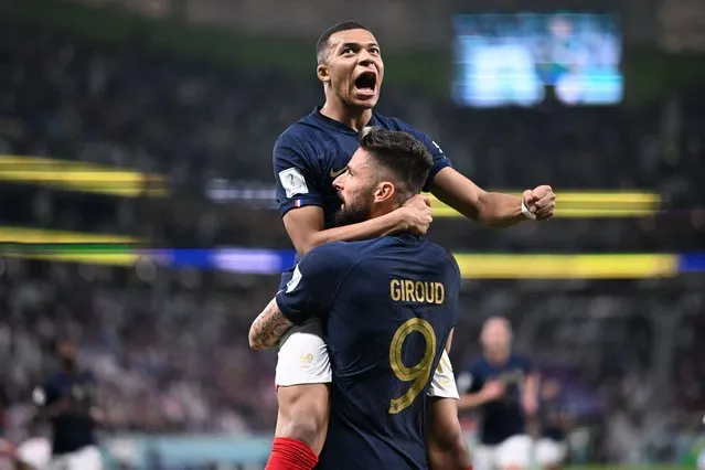 France's forward #09 Olivier Giroud celebrates with France's forward #10 Kylian Mbappe (top) after scoring his team's first goal during the Qatar 2022 World Cup round of 16 football match between France and Poland at the Al-Thumama Stadium in Doha on December 4, 2022. (Photo by Kirill Kudryavtsev/AFP Photo)