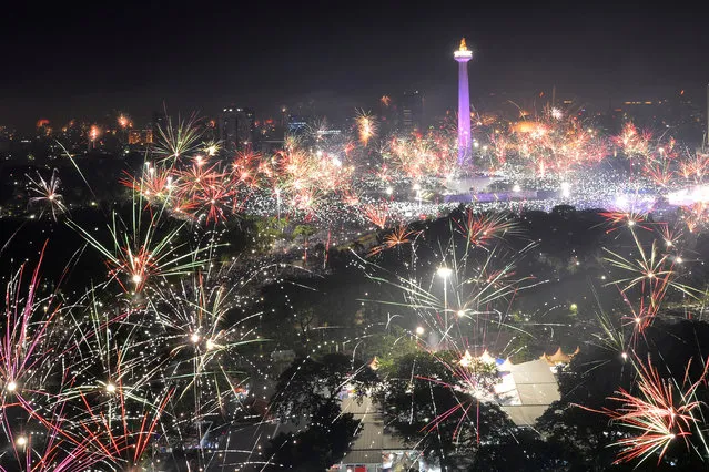 Fireworks explode around National Monument during New Year celebration in Jakarta, Indonesia on December 31, 2017. (Photo by Wahyu Putro/Reuters/Antara Foto)