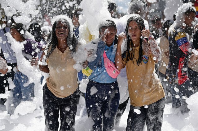 People play with foam during a government rally to mark Youth Day in Caracas, Venezuela on February 12, 2025. (Photo by Gaby Oraa/Reuters)