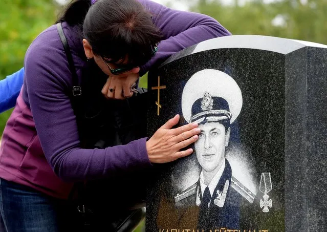 Relatives visit the graves of those who died in the Kursk submarine disaster at Saint Petersburg's Serafimovskoe cemetery during a memorial ceremony on the 20th anniversary of the tragedy on August 12, 2020. On August 12, 2000, the accidental explosion of a torpedo caused the sinking of the nuclear submarine Kursk, flagship of the Russian Navy. (Photo by Olga Maltseva/AFP Photo)