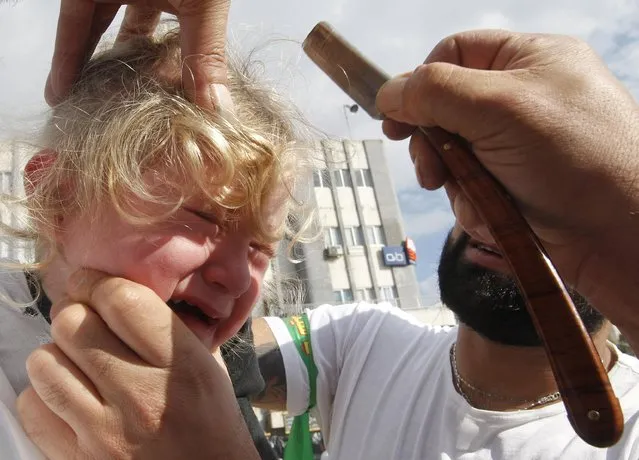 A Shi'ite Muslim girl reacts to a razor during a Muharram procession to mark Ashoura in Nabatieh town, southern Lebanon November 4, 2014. (Photo by Ali Hashisho/Reuters)