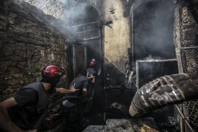 Firefighters extinguish a fire following an airstrike by forces loyal to the Syrian government in the rebel-held area of Douma, outskirts of Damascus, Syria, 11 September 2016. The strikes come a day ahead of a ceasefire agreed on between Russia and USA, and agreed on by Syria's government, which will take effect on 12 September. (Photo by Mohammed Badra/EPA)