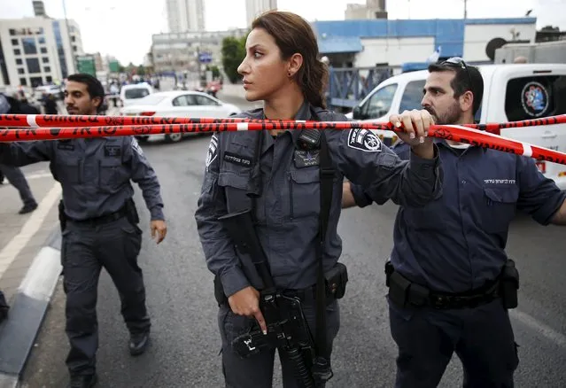 Israeli police officers patrol near a cordon at the scene of a stabbing attack in Tel Aviv, Israel October 8, 2015. Four people, including an Israeli soldier, were stabbed and wounded near a military headquarters in Tel Aviv on Thursday, police and ambulance sources said, as a rash of such Palestinian attacks spread to Israel's commercial capital. The assailant was shot and killed by another soldier as he fled, a police spokeswoman said. (Photo by Baz Ratner/Reuters)