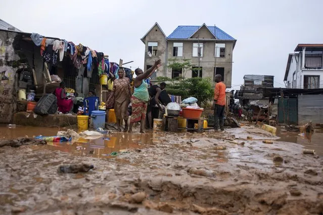 Residents clean up following torrential rains in Kinshasa, Democratic Republic of Congo, Tuesday, December 13, 2022. At least 100 people have been killed and dozens injured by widespread floods and landslides caused by the rains. (Photo by Samy Ntumba Shambuyi/AP Photo)