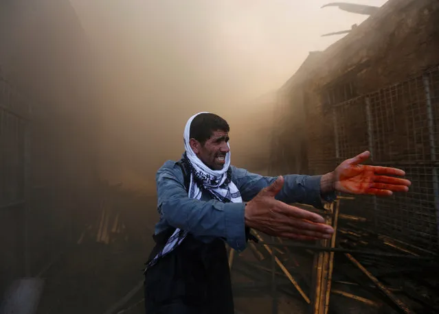 A police officer gestures as firefighters (not pictured) try to extinguish a fire which broke out at a wood market in Kabul, Afghanistan September 18, 2016. (Photo by Omar Sobhani/Reuters)