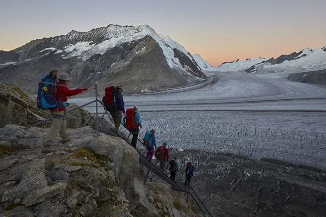 Hikers walk down steps onto the Aletsch Glacier, Switzerland, August 29, 2015. (Photo by Denis Balibouse/Reuters)
