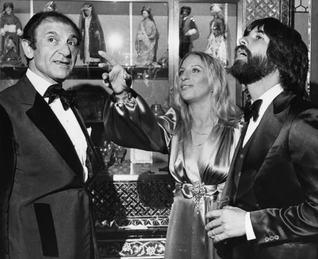 Iran's Then-Ambassador Ardeshir Zahedi, left, talks with actress Barbra Streisand and her escort Jon Peters as they admire the Iranian Embassy March 8, 1975 during a reception in Washington, D.C. Zahedi, Iran's flamboyant ambassador to the United States under its ruling shah, who charmed both the stars and politicians with his lavish parties until the 1979 Islamic Revolution, has died, Iranian state media reported Thursday, Nov. 18, 2021. He was 93. (Photo by Charles W. Harrity/AP Photo/File)