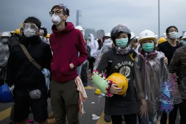 Pro-democracy protesters wearing helmets and goggles stand at a demonstration site near the office of the Chief Executive in Hong Kong December 1, 2014. Hong Kong police baton-charged and pepper-sprayed thousands of pro-democracy demonstrators in the early hours of Monday who were trying to encircle government headquarters, defying orders to retreat after more than two months of protests. (Photo by Tyrone Siu/Reuters)