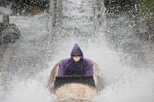 A man wearing a mask for protection against the coronavirus disease (COVID-19) gets wet from an amusement park ride, at Enchanted Kingdom in Santa Rosa, Laguna, Philippines, October 25, 2020. (Photo by Eloisa Lopez/Reuters)