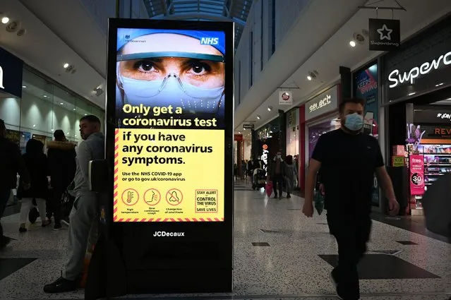 An electronic billboard displays government messages about the coronavirus pandemic in a shopping centre in Leeds, northern England, on November 1, 2020 as England prepares to enter into a second lockdown in an effort to stem soaring infections. A new four-week coronavirus lockdown in England will be extended if it fails to reduce infection rates, the government said Sunday, as it faced criticism over the abrupt decision to shut down again. The second national lockdown, hastily announced late Saturday following warnings hospitals could become overwhelmed within weeks, is set to come into force from Thursday and end on December 2. (Photo by Oli Scarff/AFP Photo)