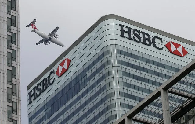A Swiss International aircraft flies past the HSBC headquarters building in the Canary Wharf financial district in east London on February 15, 2015. (Photo by Peter Nicholls/Reuters)