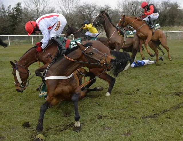 Jockey Davy Condon (left, in white) struggles to stay aboard Jamsie Hall at the 11th fence in the fourth race of the day of The Topham Steeplechase at Aintree, northern England, on April 6, 2013. (Photo by Russell Cheyne/Reuters)