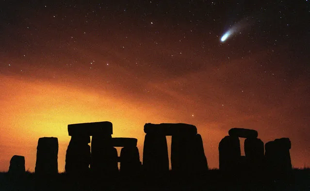 Comet Hale-Bopp seen above the ancient stone circle of Stonehenge in south west England Friday, March 28, 1997. Stonehenge, a collection of Bronze Age monuments, was constructed, according to modern archeological research, around 2000 BC. (Photo by Alastair Grant/AP Photo)