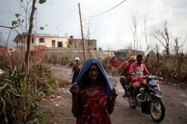 A woman protects herself from rain after Hurricane Matthew in Les Anglais, Haiti, October 13, 2016. (Photo by Andres Martinez Casares/Reuters)